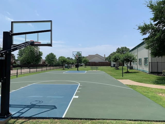 view of sport court with a lawn