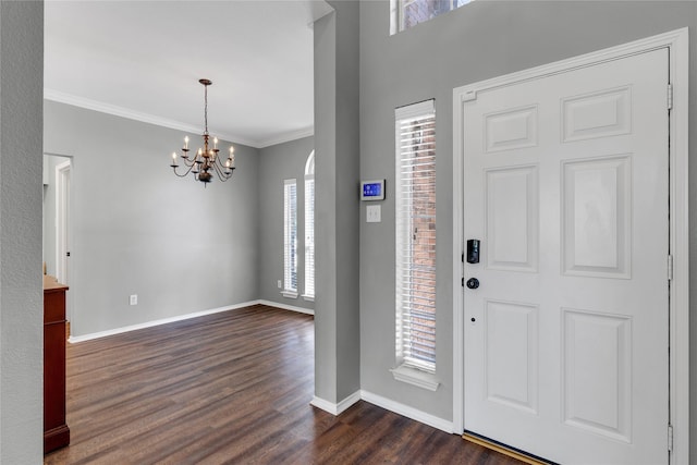 foyer with crown molding, plenty of natural light, dark hardwood / wood-style flooring, and a chandelier