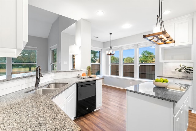 kitchen with dark stone counters, black dishwasher, sink, and white cabinets