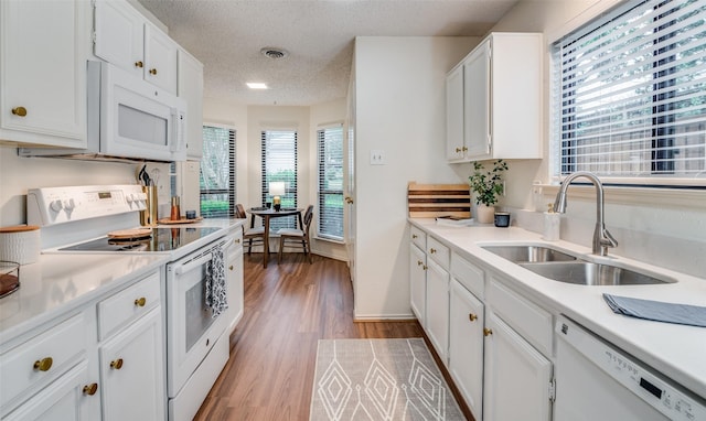 kitchen featuring sink, a textured ceiling, white appliances, light hardwood / wood-style floors, and white cabinets