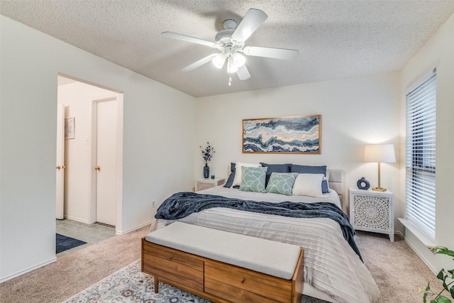 carpeted bedroom with ceiling fan and a textured ceiling