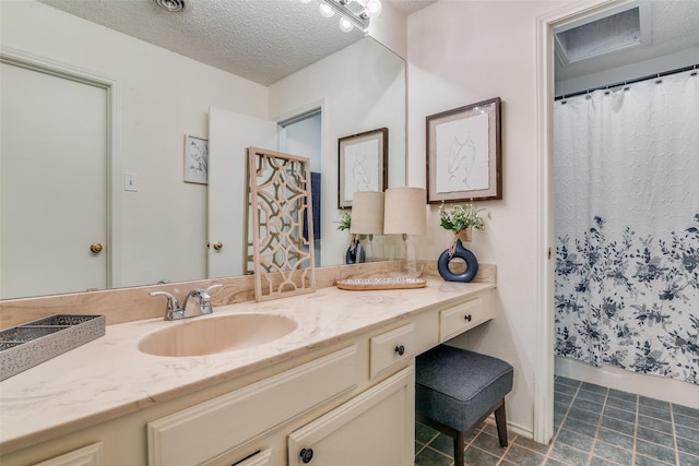 bathroom featuring tile patterned flooring, vanity, and a textured ceiling