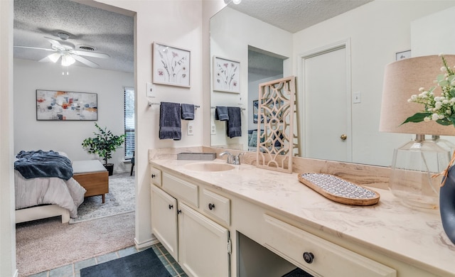 bathroom with ceiling fan, vanity, tile patterned flooring, and a textured ceiling