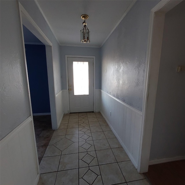 doorway with crown molding and light tile patterned floors