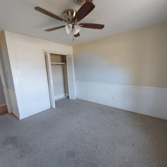 unfurnished bedroom with carpet flooring, ceiling fan, and a closet