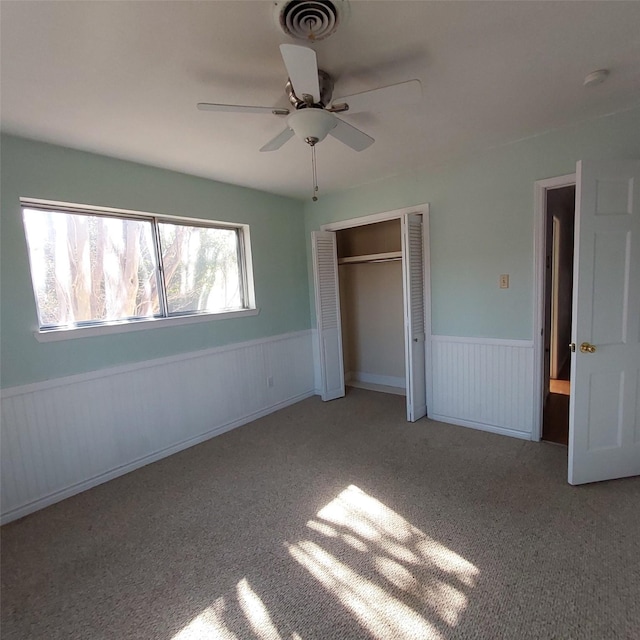 unfurnished bedroom featuring light colored carpet, ceiling fan, and a closet