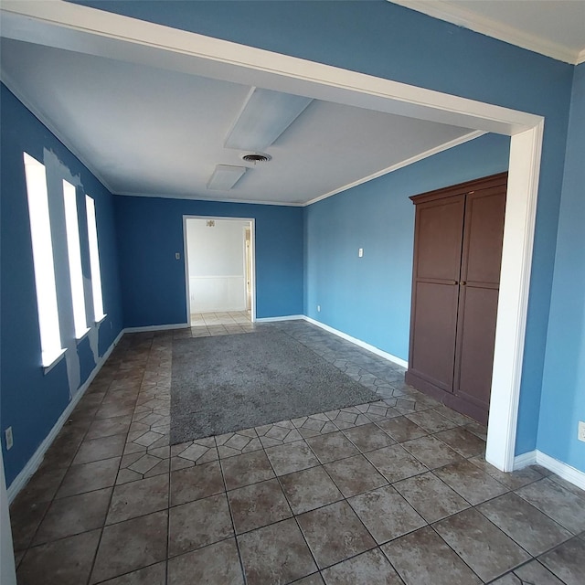 empty room featuring tile patterned flooring and crown molding