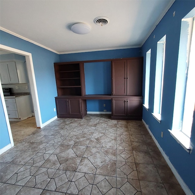 unfurnished living room featuring crown molding and built in desk