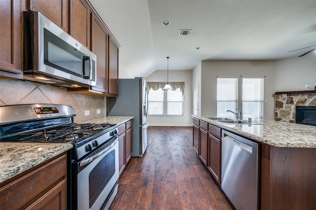 kitchen with visible vents, a sink, light stone counters, backsplash, and stainless steel appliances