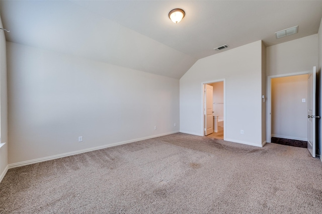 unfurnished bedroom featuring visible vents, carpet flooring, baseboards, and lofted ceiling