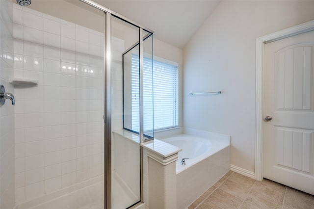 bathroom featuring tile patterned flooring, a shower stall, a garden tub, and vaulted ceiling