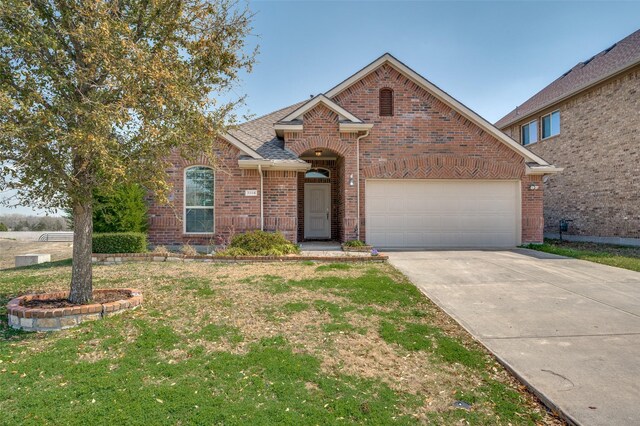 view of front of property with concrete driveway, a garage, brick siding, and a front lawn