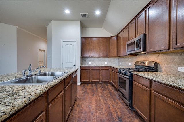 kitchen featuring tasteful backsplash, visible vents, a sink, stainless steel appliances, and dark wood-style flooring