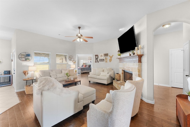 living room with dark hardwood / wood-style flooring, a fireplace, and ceiling fan