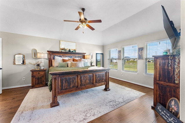 bedroom with ceiling fan, vaulted ceiling, and dark hardwood / wood-style flooring