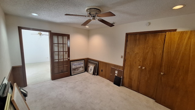 carpeted empty room with ceiling fan and a textured ceiling