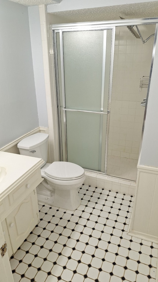 bathroom featuring vanity, toilet, and walk in shower