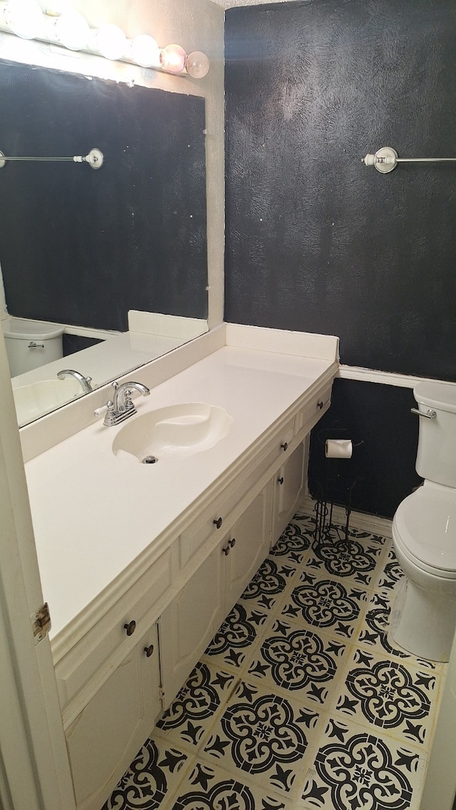 bathroom featuring tile patterned flooring, vanity, and toilet