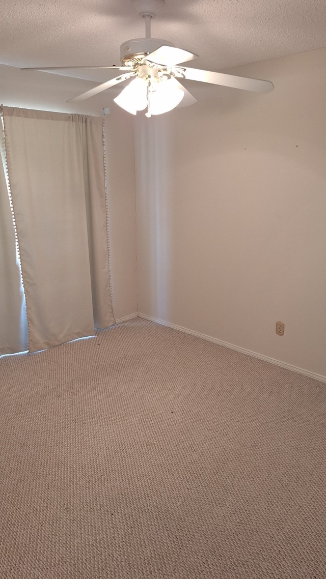 carpeted spare room with ceiling fan and a textured ceiling