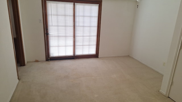 spare room featuring light colored carpet