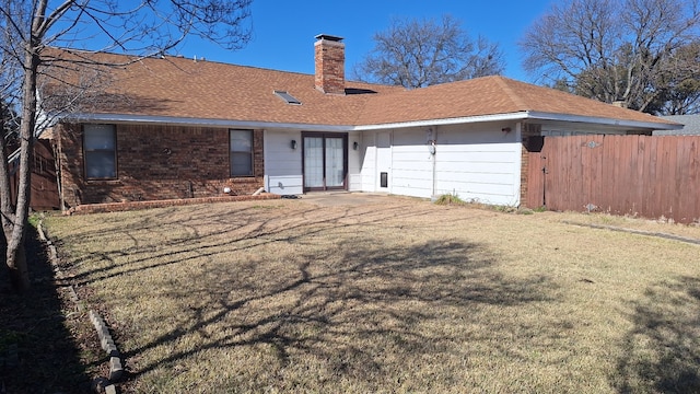 rear view of house featuring a lawn