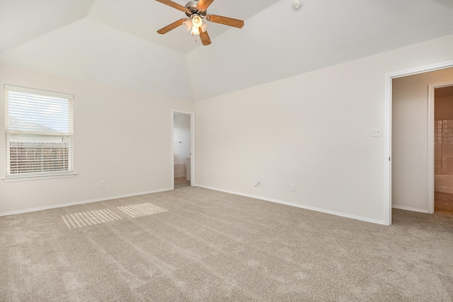 carpeted spare room featuring lofted ceiling and ceiling fan