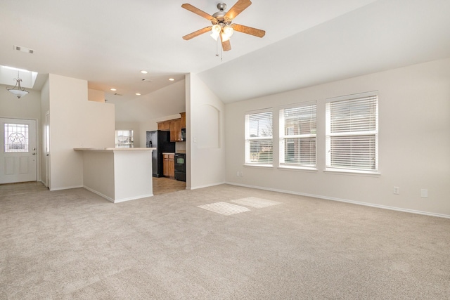 unfurnished living room featuring plenty of natural light, light colored carpet, ceiling fan, and vaulted ceiling