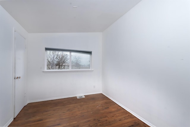 unfurnished room with dark wood-type flooring