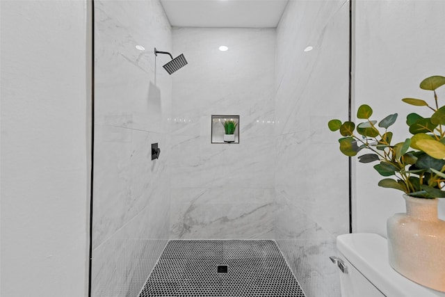 bathroom with toilet and tiled shower