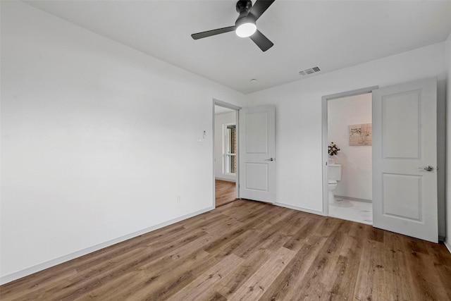 unfurnished bedroom featuring ceiling fan, ensuite bath, and light hardwood / wood-style flooring