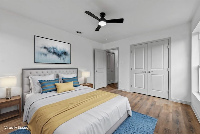 bedroom with hardwood / wood-style flooring, ceiling fan, and a closet