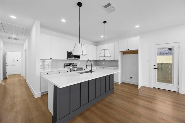 kitchen with sink, white cabinetry, decorative light fixtures, a center island with sink, and electric range