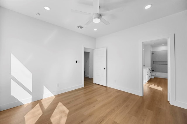 unfurnished bedroom featuring ceiling fan, ensuite bath, and light wood-type flooring