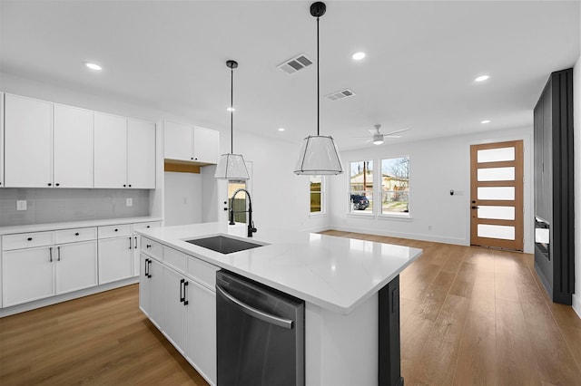 kitchen with sink, light hardwood / wood-style flooring, a center island with sink, dishwasher, and white cabinets