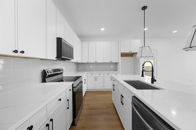 kitchen with pendant lighting, sink, black dishwasher, white cabinets, and stainless steel electric stove