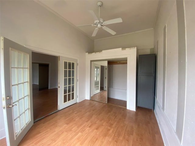 interior space featuring french doors, crown molding, vaulted ceiling, and light wood-type flooring