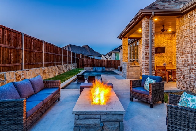 patio terrace at dusk with an outdoor living space with a fire pit