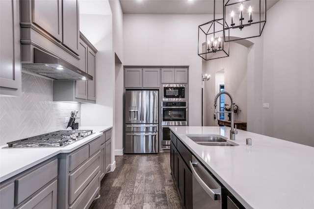 kitchen featuring dark wood-type flooring, a sink, light countertops, appliances with stainless steel finishes, and gray cabinets