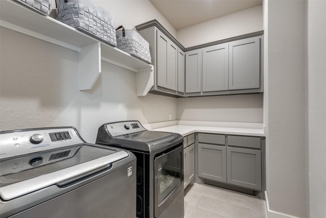 washroom featuring light tile patterned floors, independent washer and dryer, and cabinet space