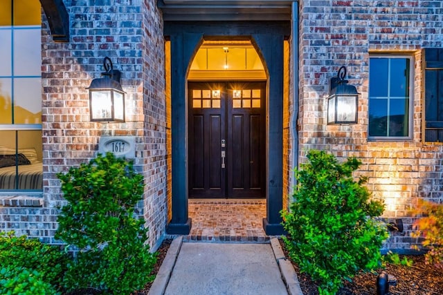 entrance to property featuring brick siding