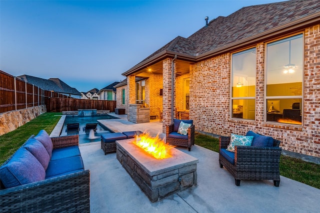 patio terrace at dusk featuring an outdoor living space with a fire pit