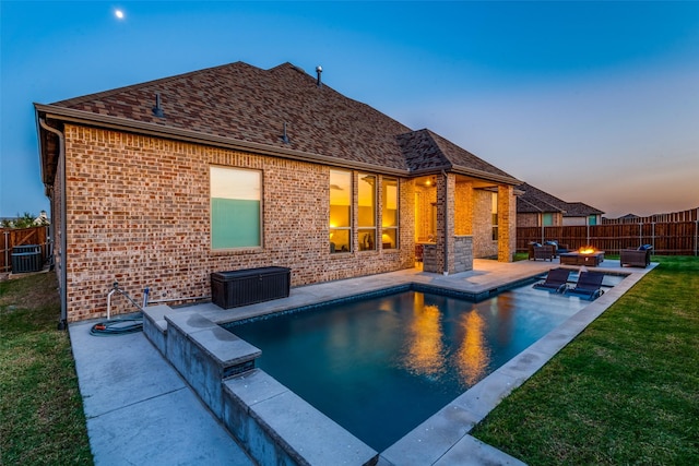 back house at dusk featuring a fenced in pool, a yard, central AC, a patio, and an outdoor fire pit