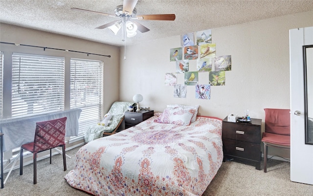 bedroom featuring ceiling fan, light colored carpet, and a textured ceiling