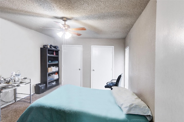 bedroom with ceiling fan, carpet flooring, and a textured ceiling