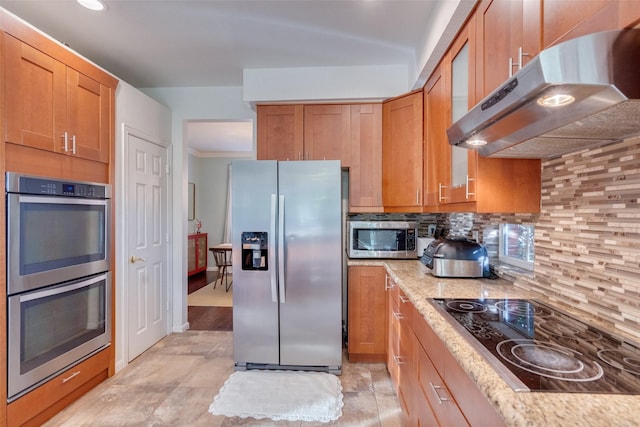 kitchen featuring light stone countertops, appliances with stainless steel finishes, and backsplash