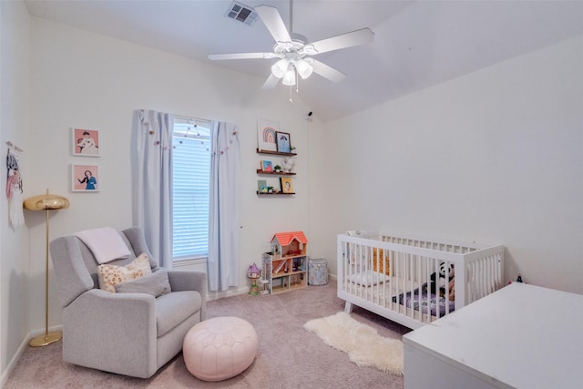 carpeted bedroom with lofted ceiling, a nursery area, and ceiling fan