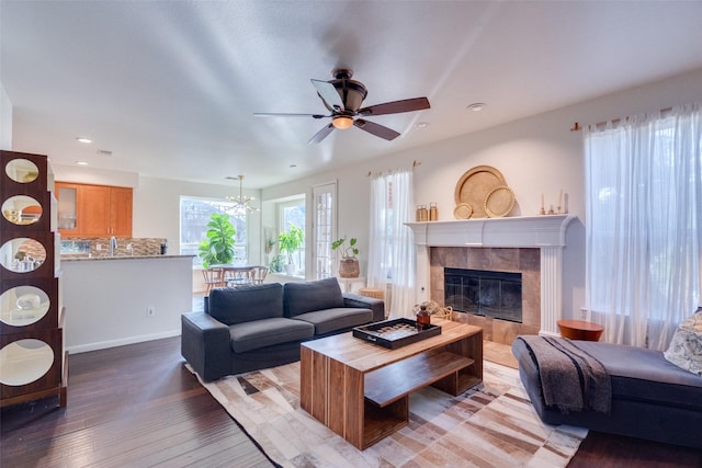 living room featuring wood-type flooring, ceiling fan, and a fireplace