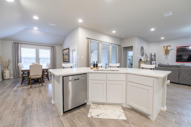 kitchen featuring a center island with sink, sink, stainless steel dishwasher, and white cabinets