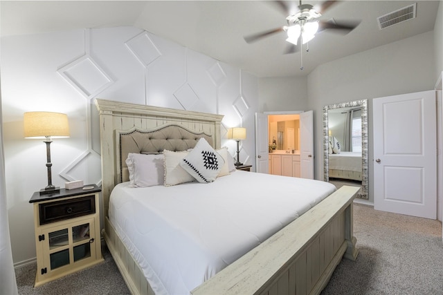 carpeted bedroom with ensuite bath, vaulted ceiling, and ceiling fan