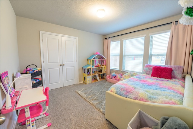 carpeted bedroom with a closet and a textured ceiling